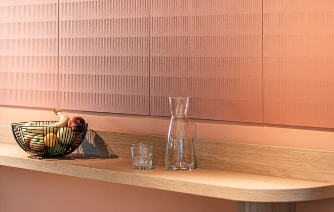 Terracotta Paper Waste Panels made from recycled paper waste as wall cladding above an oak bar counter with stools
